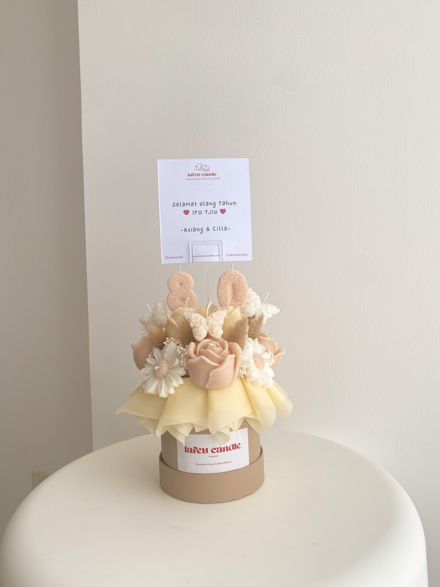 Jina Buket Bunga dari Lilin berwarna beige kecoklatan dengan bunga daisy, mawar, dan topper angka 80 dan kupu-kupu